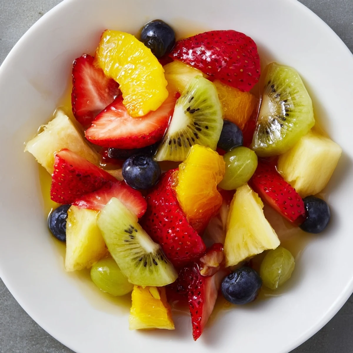 This easy fruit salad features colorful berries and pineapple, drizzled with a light citrus glaze.
