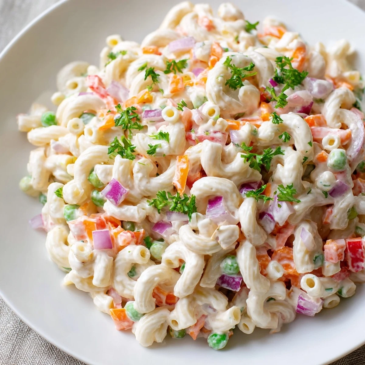 Creamy macaroni salad, a classic side, features chilled pasta with colorful diced vegetables.