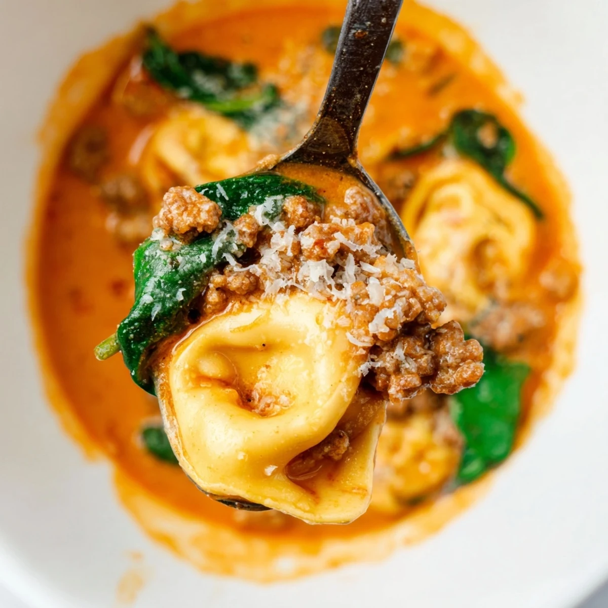 A cozy bowl of Tuscan Tortellini Soup garnished with fresh basil, ready to serve with crusty bread.