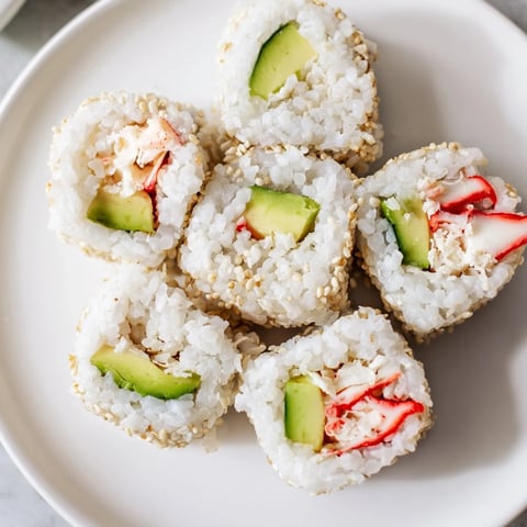 Freshly made California roll sushi with vibrant avocado and sesame seeds, ready to enjoy.