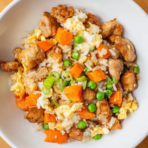 Golden chicken fried rice with fluffy rice and colorful vegetables, ready to eat.