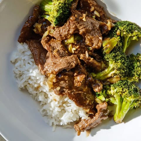 A steaming bowl of flavorful Beef and Broccoli stir-fry, showcasing savory beef and vibrant broccoli.