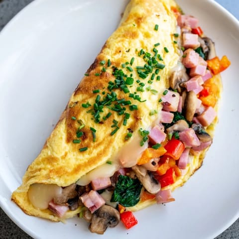 A golden-brown Omelet with Cheese, perfectly folded with melted Gruyère, ready to savor.
