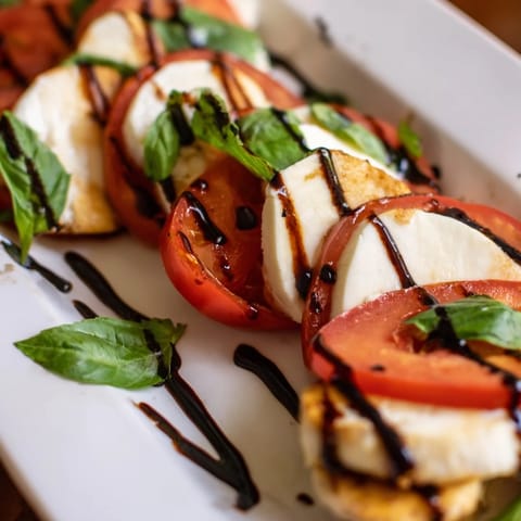Bright Mediterranean flavors with juicy grilled chicken, creamy mozzarella, and ripe tomatoes on a platter.  
